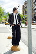 © Elena Kharichkina/Stocksy - Man standing on a traffic barrier in city street