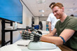 © Alvaro Lavin/Stocksy - Patient testing robotic hand prosthesis in medical laboratory
