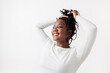 © Jovo Jovanovic/Stocksy - Smiling woman with hands in hair, wearing white.