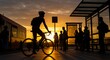 © Supardi - Cyclist silhouettes at sunset, passing a bus stop where people wait patiently for transport.