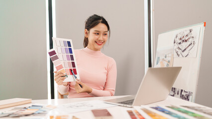 Asian Woman User Interface Designer Chooses Color Palette for Website Mockup on Laptop Screen for Client Online Meeting