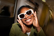 © Alvaro Lavin/Stocksy - Smiling Woman Wearing Stylish White Sunglasses