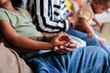 © Jovo Jovanovic/Stocksy - Family relaxes together on a couch, holding hands.