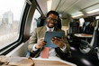 © Mihajlo Ckovric/Stocksy - Black Businessman Using Digital Tablet While Traveling on Modern Train