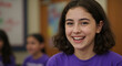 © Vasiliy - Laughing girl with curly dark hair in purple shirt with classroom background. Joyful student expression for elementary education and learning engagement programs