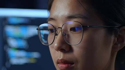 Asian woman software developer looking at code lines closeup