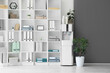 © Pixel-Shot - Modern water cooler with paper cups and shelf unit in office