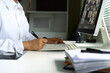 © Prathankarnpap - Close up of woman taking notes while attending a virtual meeting on her desktop computer