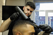 © Dmytro Hai - Barber drying hair of african american client