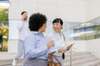 © Westend61 - Business team having a conversation while walking outside an office building