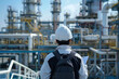 ©  A-photos - 複雑な配管が広がるプラント施設を確認する日本人作業員の後ろ姿