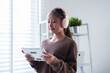 © snowing12 - Young Asian woman enjoys tablet with headphones at home