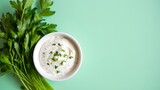 Creamy homemade ranch dressing recipe with fresh parsley and herbs on light green background