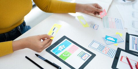 Website designer, Creative planning phone app development template layout framework wireframe design, User experience concept, Young asian UX designer working on smartphone application at office.