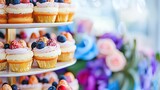   A three-tiered display of cupcakes topped with fresh berries, including blueberries