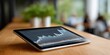 © Iryna - Tablet displaying financial stock chart on wooden table in modern office setting