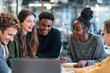 © Gamenin - Diverse group of young adults collaborate on a project, leaning in together around a laptop and notebook, smiles and engagement evident