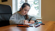 © MOHAMED - Ultra HD photo of autistic teen focused on drawing at art desk with colored pencils and warm lighting