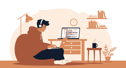 Young Coder Working At His Desk With Laptop And Headphones At Home