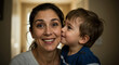 © NN AI - Smiling mother receiving kiss from toddler son indoors. Caucasian woman with dark hair and child showing affection. Maternal love and family bonding concept