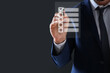 © New Africa - Businessman putting tick in check list on virtual screen against dark grey background, closeup