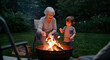 © ZUZU - Grandparent and grandchild roasting marshmallows