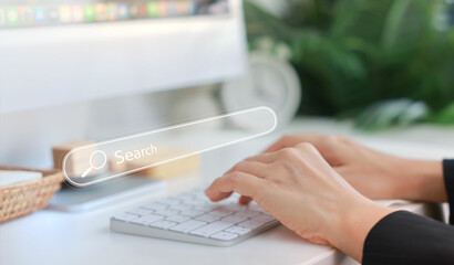 hands typing on a white keyboard with search bar overlay, representing internet browsing, seo, onlin