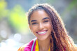 © Alina - Smiling african female teen with curly hair outdoors in bright sunlight