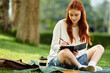 © Bliss - Beautiful young woman enjoys a peaceful afternoon writing in a sunny park