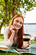 © Bliss - Young woman enjoys a sunny afternoon sipping coffee in a lush green park