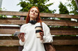 © Bliss - Young woman enjoys a coffee while relaxing outdoors during her spare time