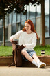 © Bliss - Young woman enjoys leisurely afternoon outdoors while organizing her backpack
