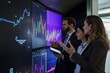 © Phanudat Manphatthan - Group of investors discussing stock performance in front of a large screen display.