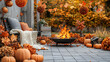 © GERHARD - Cozy autumn patio with fire pit.  Fall decorations, pumpkins, blankets, and a warm fire create a welcoming atmosphere