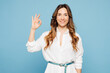 © ViDi Studio - Young fun happy successful employee business woman corporate lawyer wear shirt classic formal clothes work in office showing okay ok gesture isolated on pastel light blue background studio portrait.
