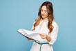 © ViDi Studio - Young successful employee business woman corporate lawyer she wears shirt formal clothes work in office hold clipboard read paper account documents isolated on pastel blue background studio portrait.