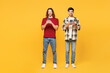 © ViDi Studio - Full body young smiling fun two friends buddies men they wear casual clothes together hold in hand use mobile cell phone isolated on plain yellow orange background studio portrait. Lifestyle concept.