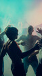 © master1305 - Silhouetted people dancing in colorful fog, capturing a lively nightclub atmosphere. Concept of nightlife party, youth, summer, festivity, celebration