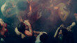 © master1305 - Group of people dancing at a party, vibrant atmosphere with dim lighting and smoke. Concept of nightlife party, youth, summer, festivity, celebration