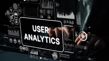 hands typing on keyboard with user analytics data visualization and graphs on screen in modern offic