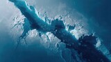 Top down Satellite view of a colossal iceberg breaking apart intricate cracks and deep blue hues
