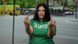 © Krakenimages.com - Volunteer woman making gestures on a busy city street wearing a green shirt outdoors in an urban setting showing emotion and expression
