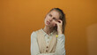 © Krakenimages.com - Woman holds hand near chin while thinking in a studio framed by warm light highlighting blonde young hair in a creative portrait conveying strong expression on the face.
