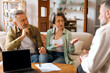 © Home-stock - Senior couple talking to real estate agent about house purchase at meeting, advisor consulting older family, laptop with blank screen on desk