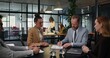 © m-art - A business man and a woman sign a contract sitting at a desk during an office meeting. They shake hands.