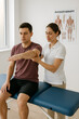 © Elena - Physiotherapist Assisting Male Patient with Arm Rehabilitation Exercise