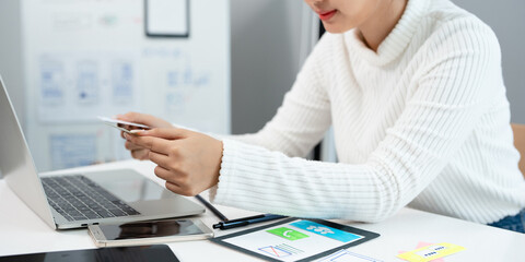 Website designer, Creative planning phone app development template layout framework wireframe design, User experience concept, Young asian UX designer working on smartphone application at office.