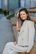 © SHOTPRIME STUDIO - smiling woman in beige business suit outdoors urban background casual confident young adult