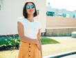 © halayalex - Portrait of beautiful smiling brunette model dressed in summer hipster  clothes. Trendy female posing in the street near white wall. Funny and positive woman having fun