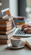 © tong2530 - Vertical close-up of student's desk setup with stacked textbooks, coffee cup, open laptop, hands typing, soft focus background, conveying discipline and self-study routine
